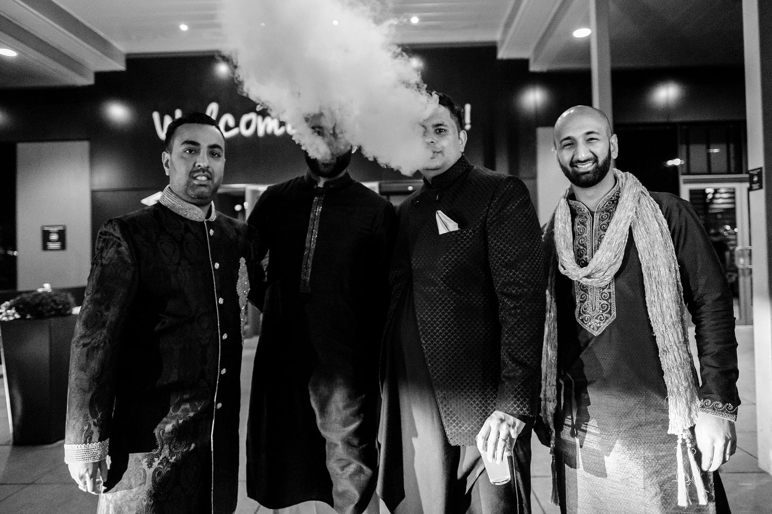 Black and white photograph of guests gathered at an elegant indoor celebration venue.