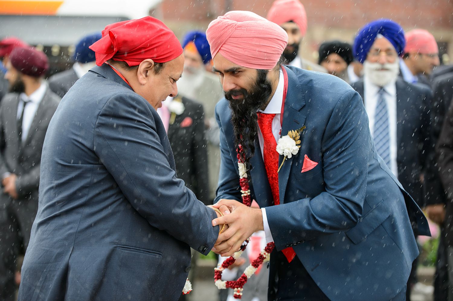 Group of people in colorful turbans gathering at an outdoor event.