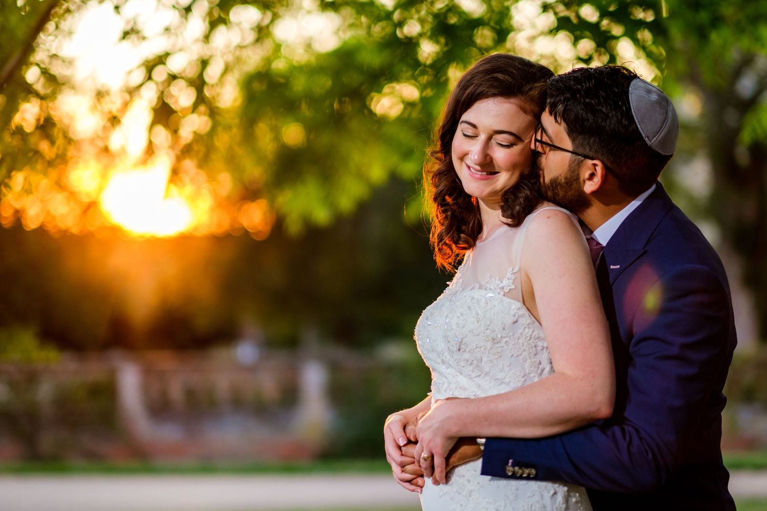 Romantic sunset wedding portraits with golden hour lighting in an outdoor garden setting.