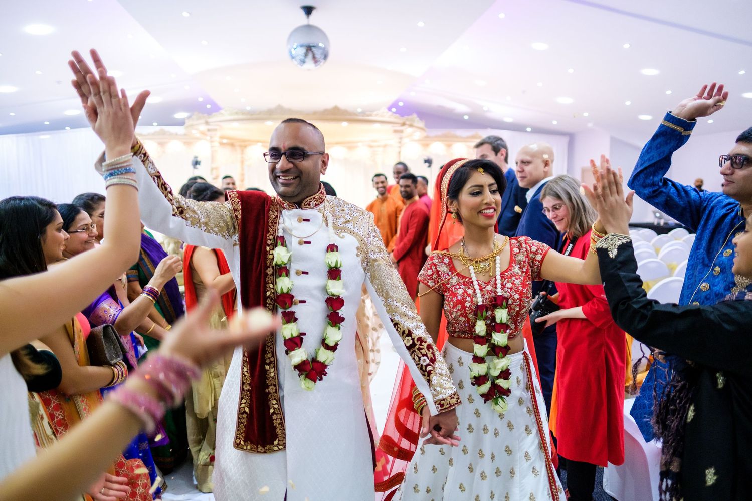 Newlyweds celebrating with guests throwing confetti during wedding ceremony recessional.
