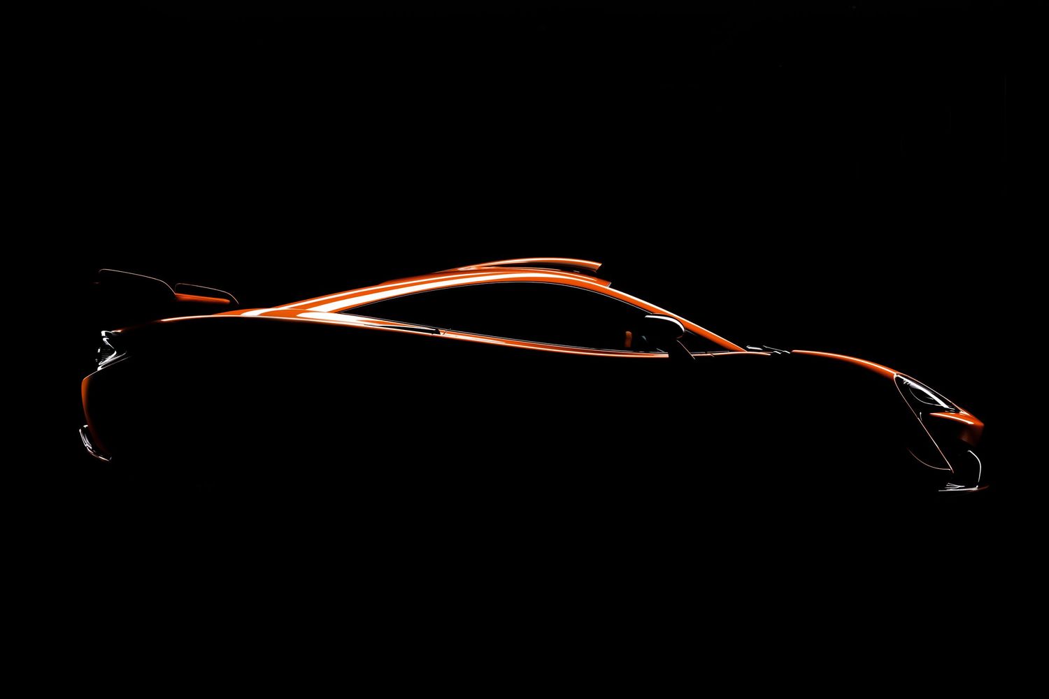 Sleek silhouette of an orange supercar concept shown in dramatic dark lighting against black background.