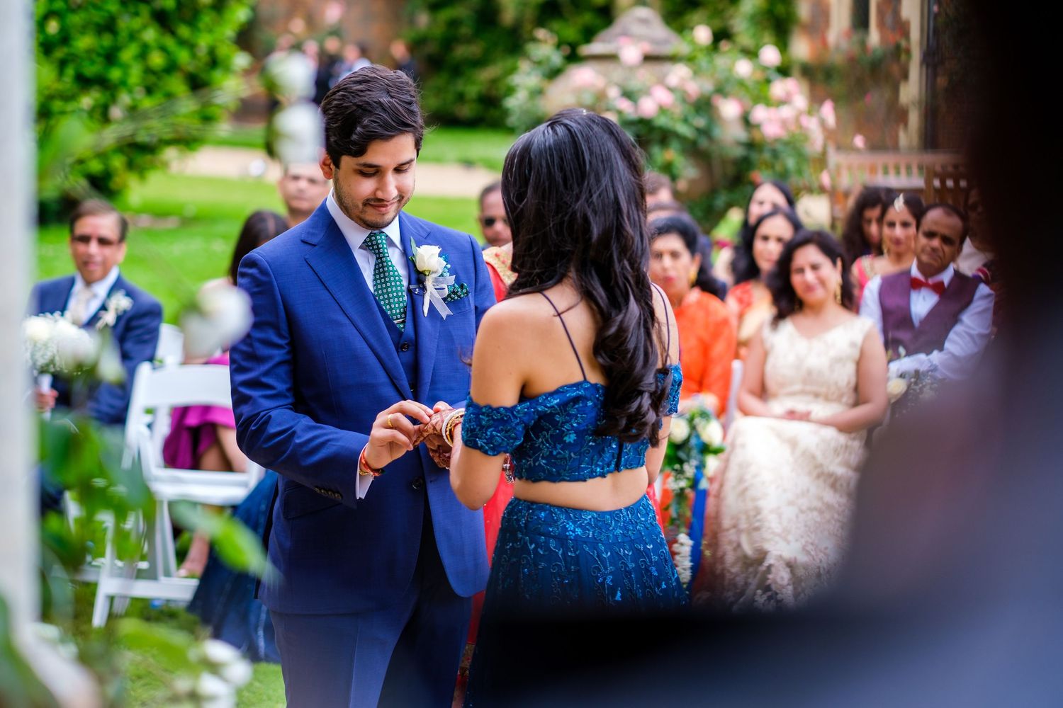 Wedding celebration in a garden setting with guests dancing and mingling on the lawn.