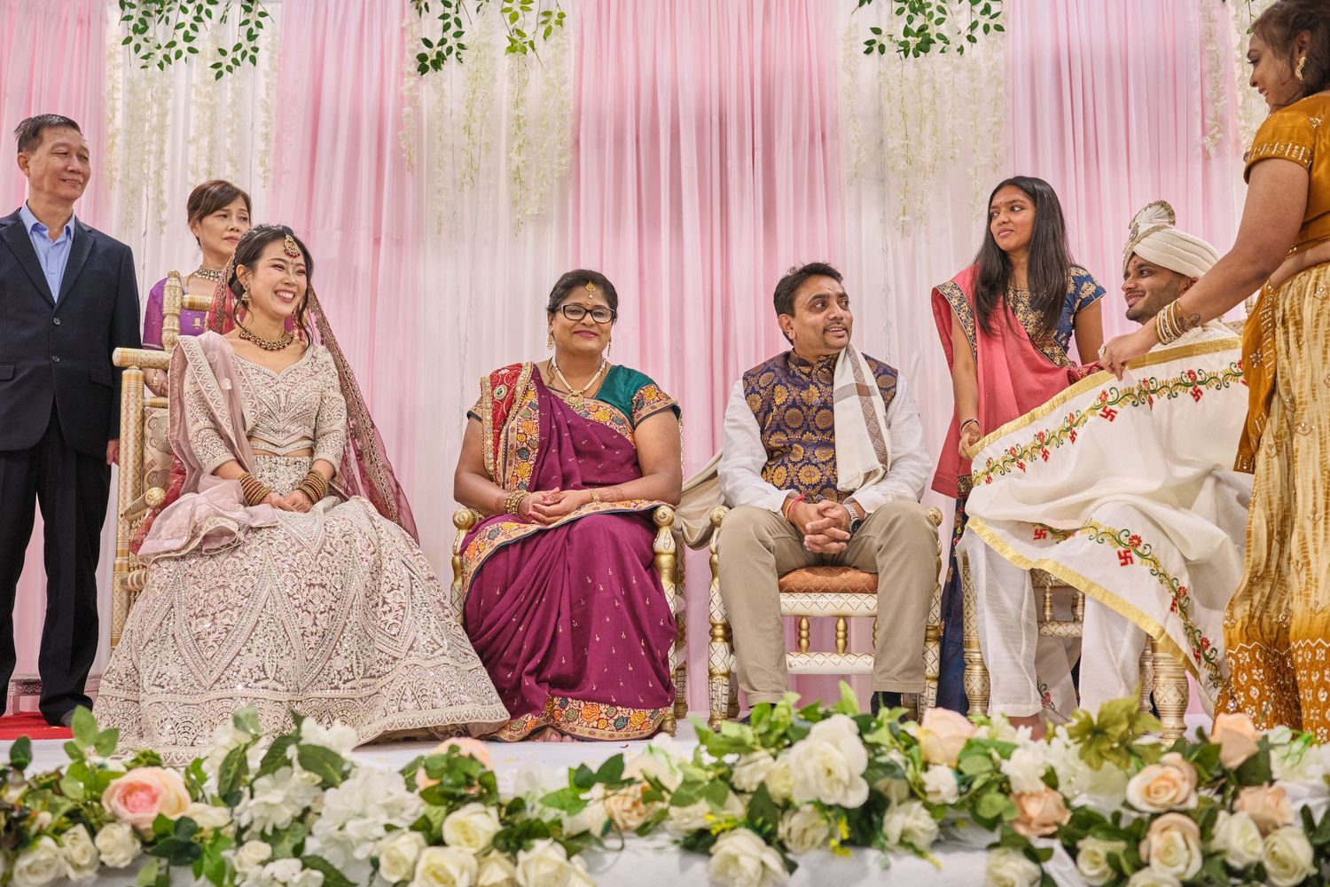 Traditional Indian wedding ceremony setup with pink drapery and floral decorations during reception celebrations.