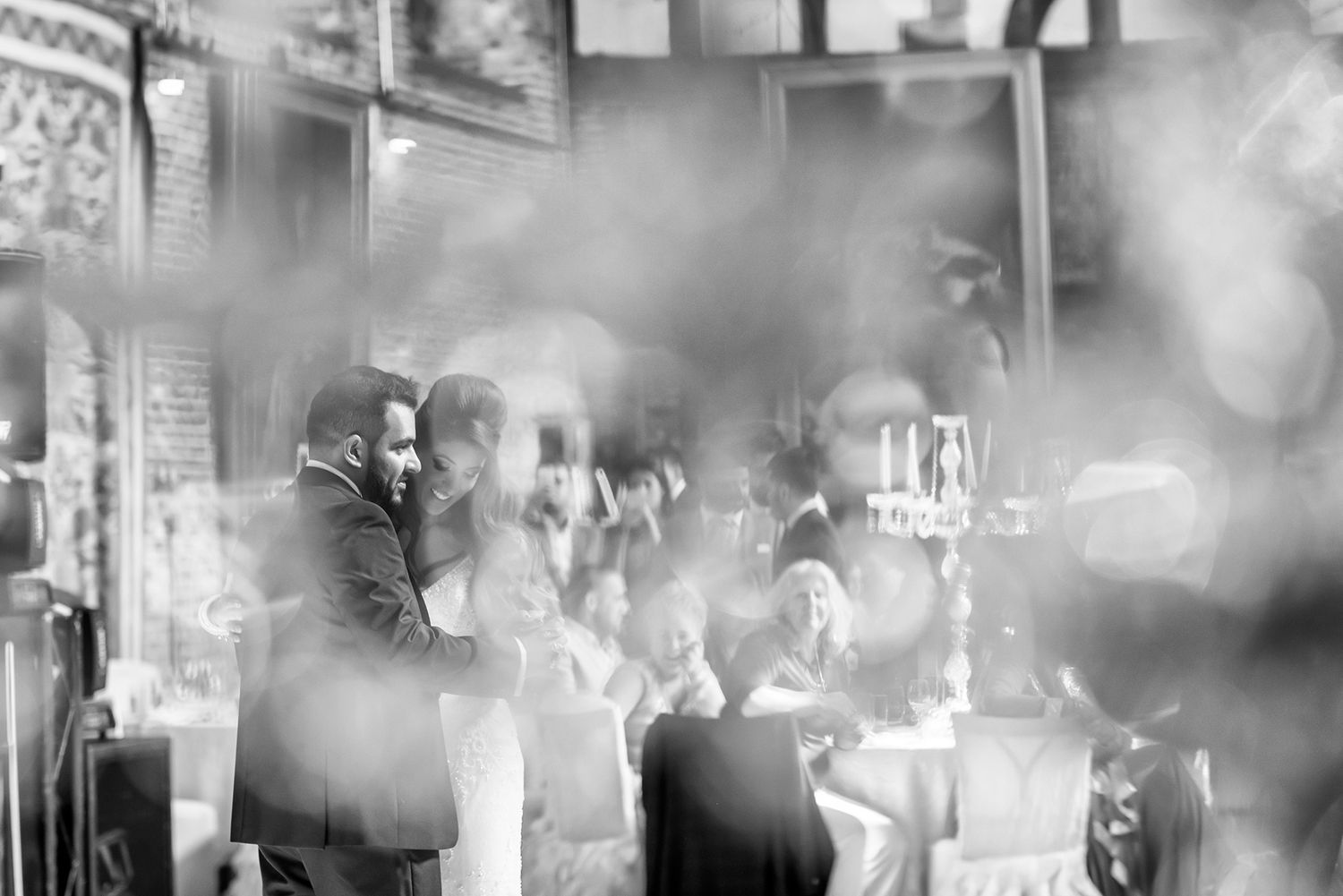 Black and white reception photos capturing celebration moments through artistic bokeh effects.