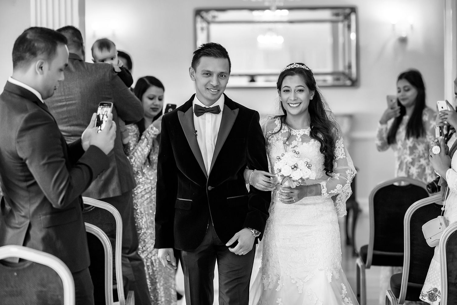 Wedding party celebrating in formal attire at an indoor venue.