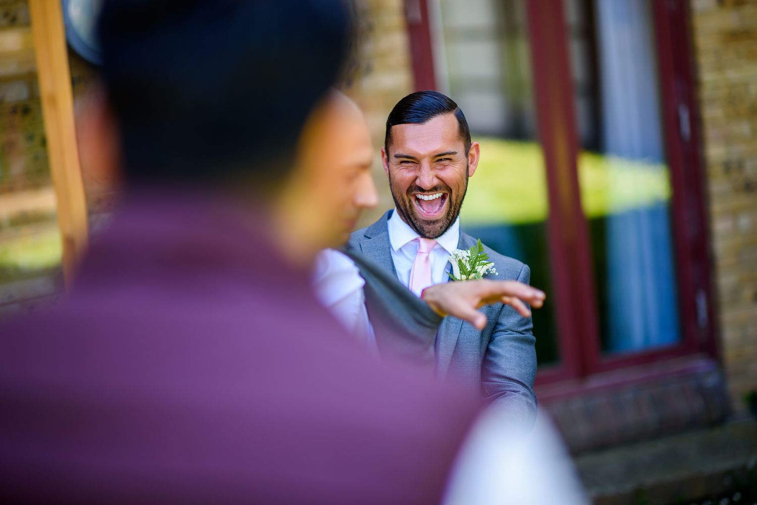 Guests laughing and smiling during a joyful wedding celebration.