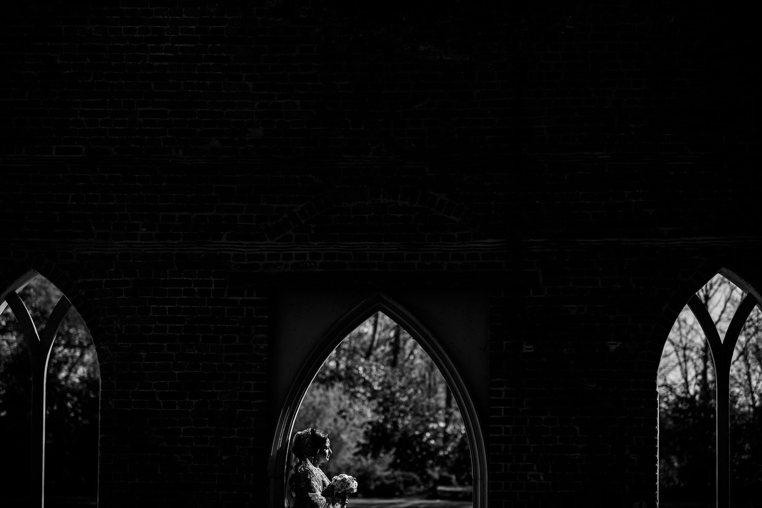 Gothic church windows silhouetted against dark interior space.