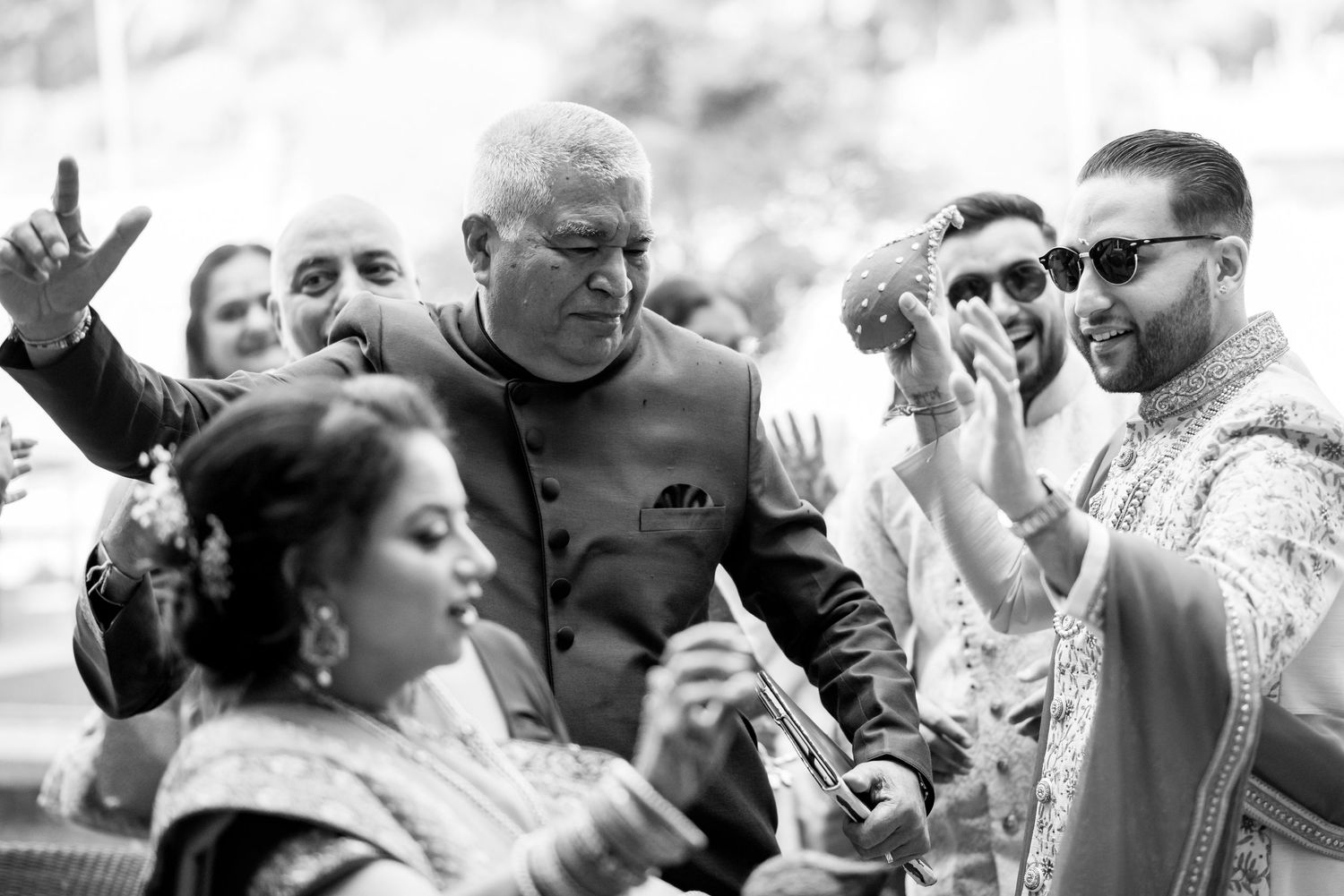 Wedding guests enjoy a candid moment outdoors during a sunny celebration.