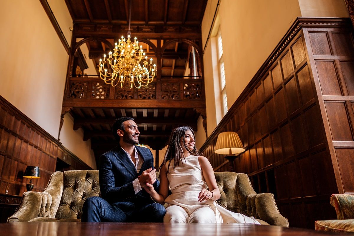 Warm-toned interior shot of vintage room with chandelier and wood paneled walls.