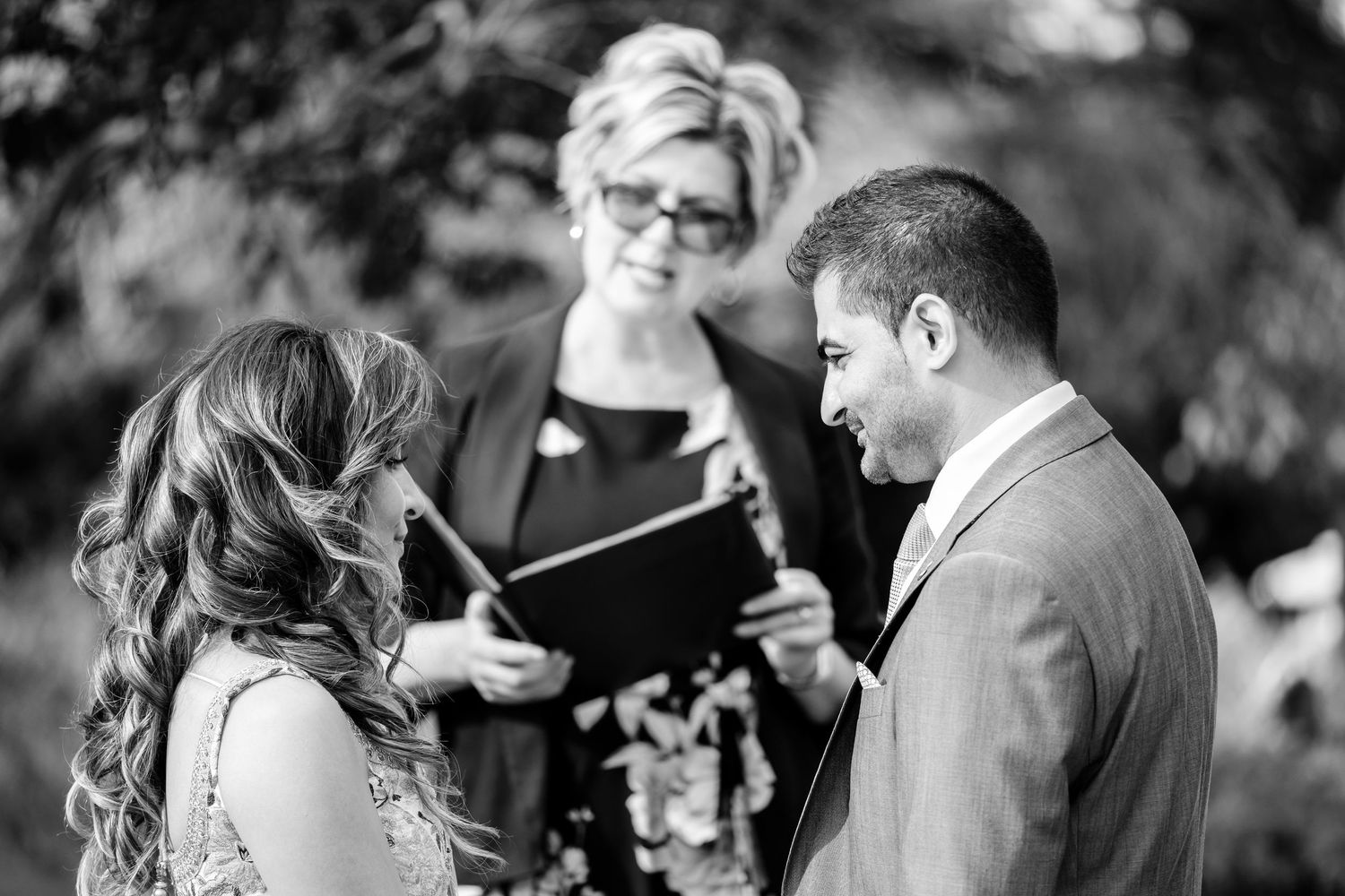 Candid black and white wedding photography showing emotional exchanges during the ceremony.