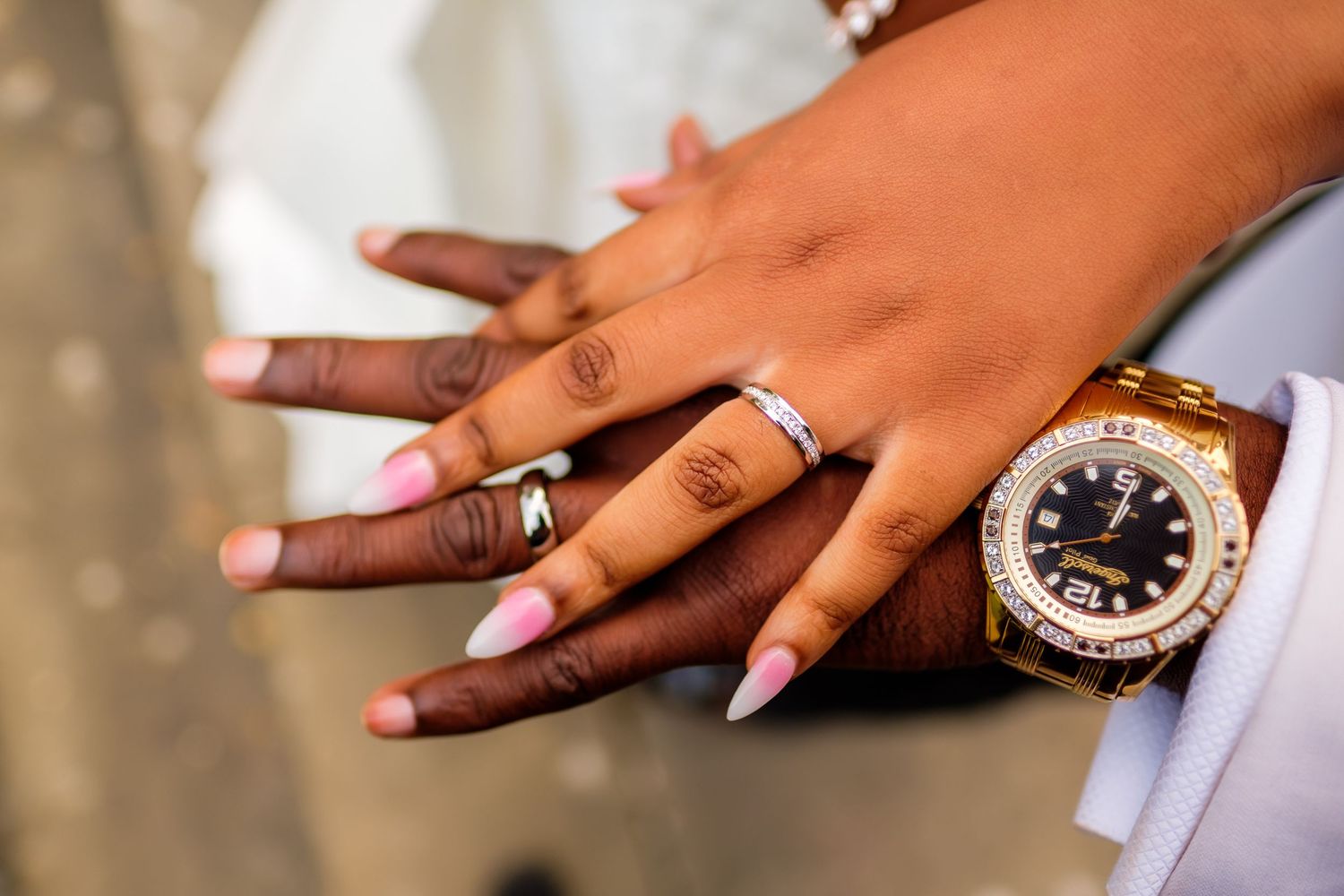 Close-up shots of wedding rings and manicured hands.