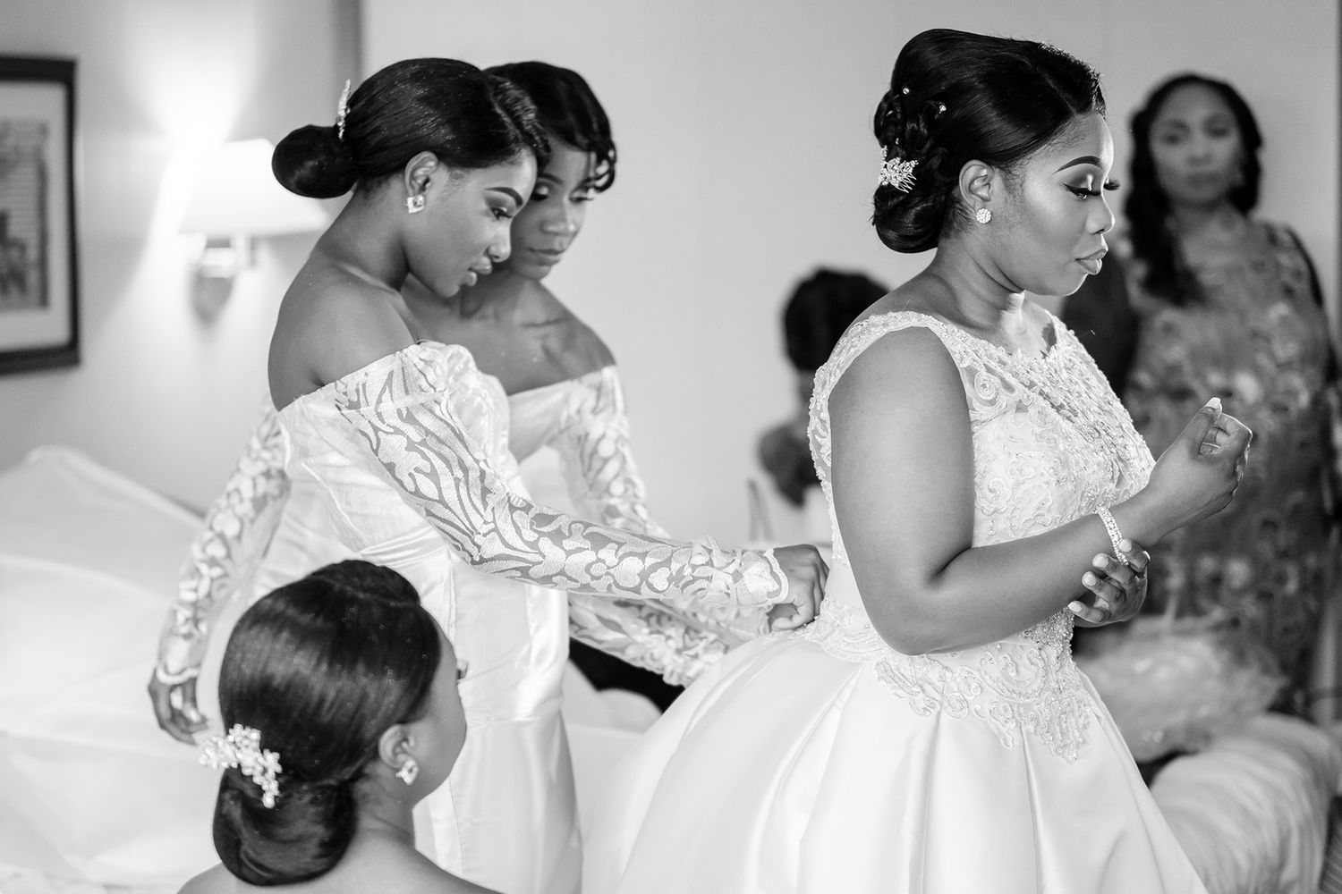 Black and white photo of wedding preparations showing elegant lace dresses.