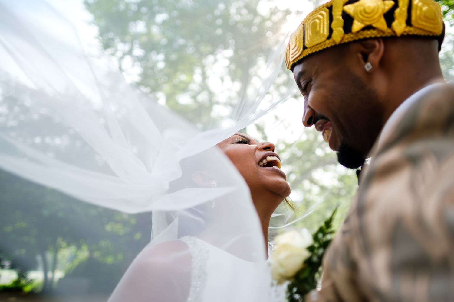 Elegant wedding couple shares an intimate moment in a sun-dappled garden setting.