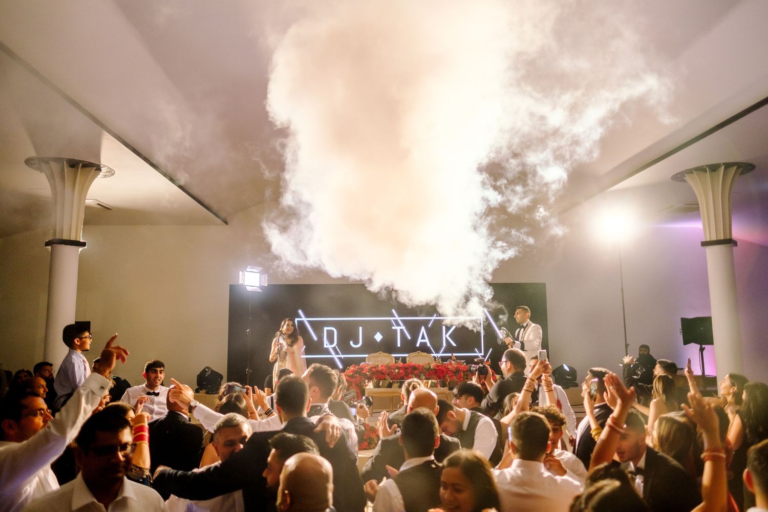 Wedding reception dance floor filled with fog effects and party lighting.