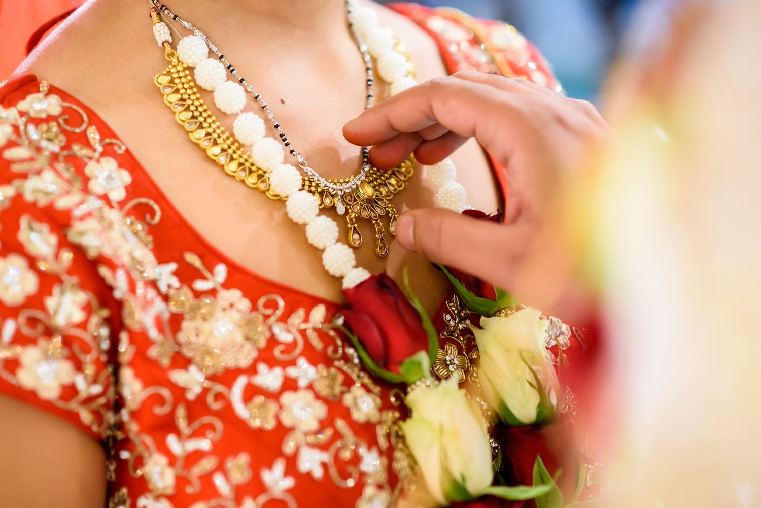 Close-up details of intricate bridal jewelry and accessories in red and gold colors.