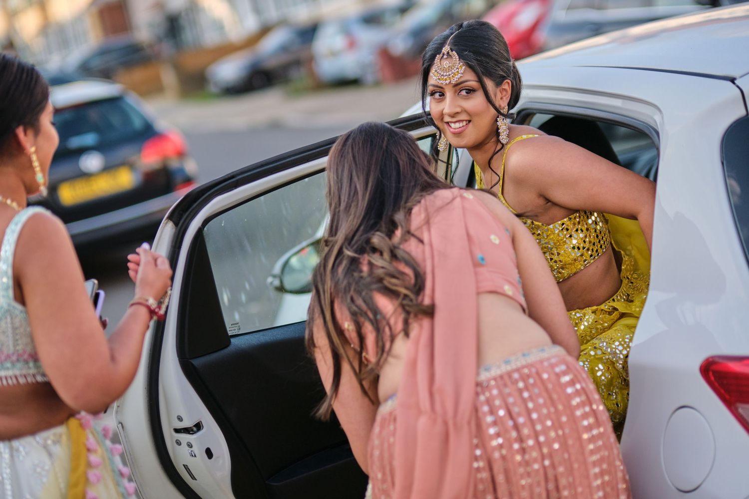Wedding guests in colorful traditional attire gather outside during a celebration.