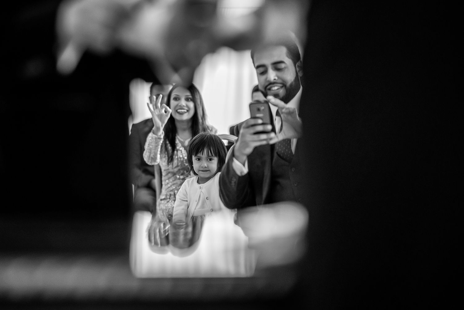 Wedding celebration candid moments captured through creative framing and lighting.