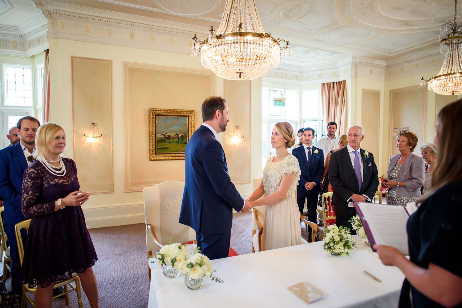 Formal dining room with crystal chandeliers and classic decor during wedding celebration.