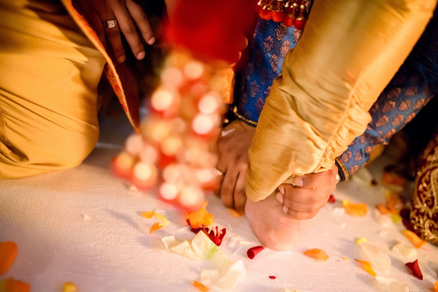 Rose petals scatter across the floor during an Indian wedding celebration.