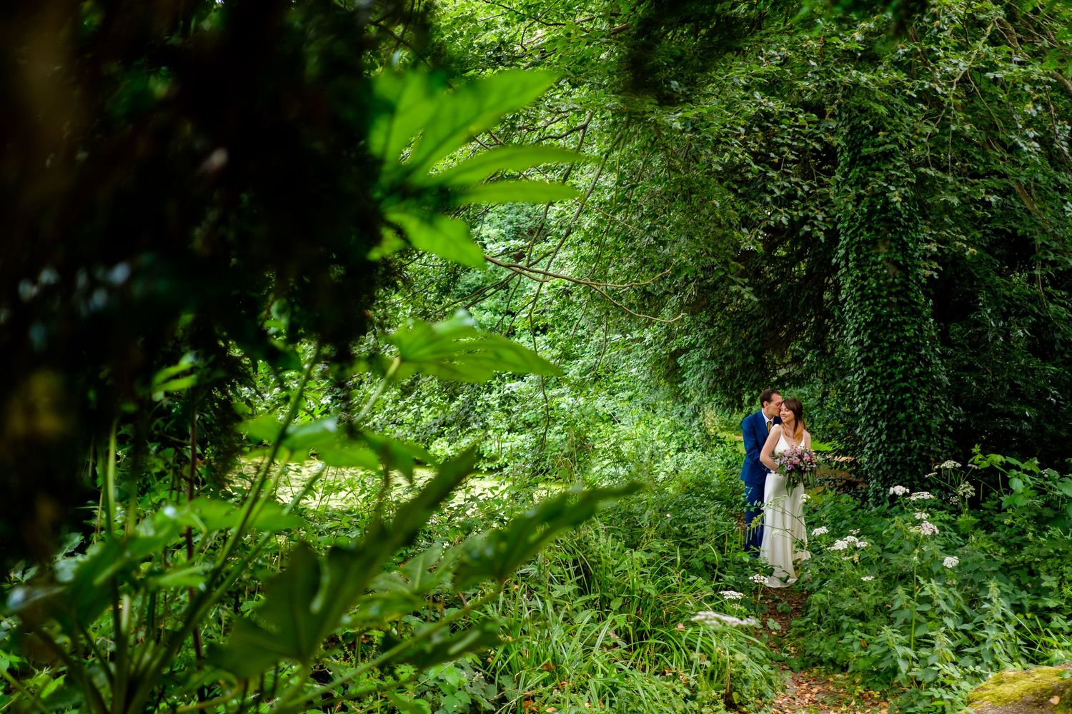 Wedding photography in vibrant green garden setting with natural light.