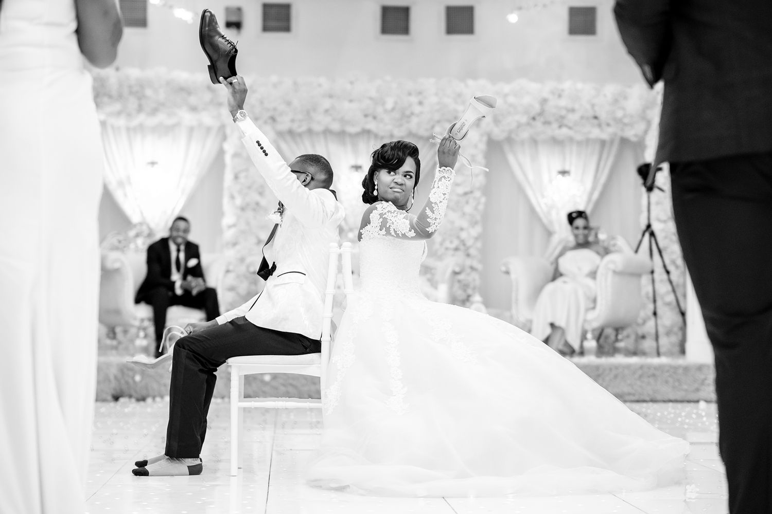Wedding party members dancing and celebrating in an elegantly decorated venue.