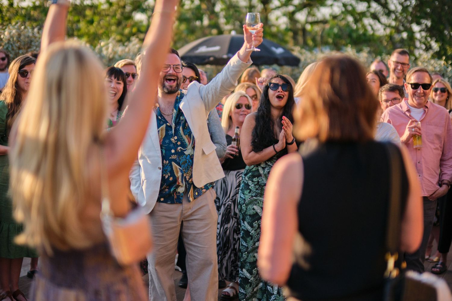 Crowd of people dancing and celebrating at an outdoor event.