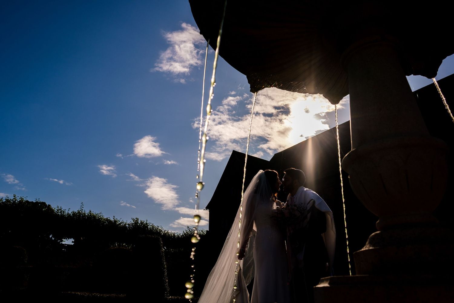 White fabric flutters against a deep blue sky with scattered clouds.