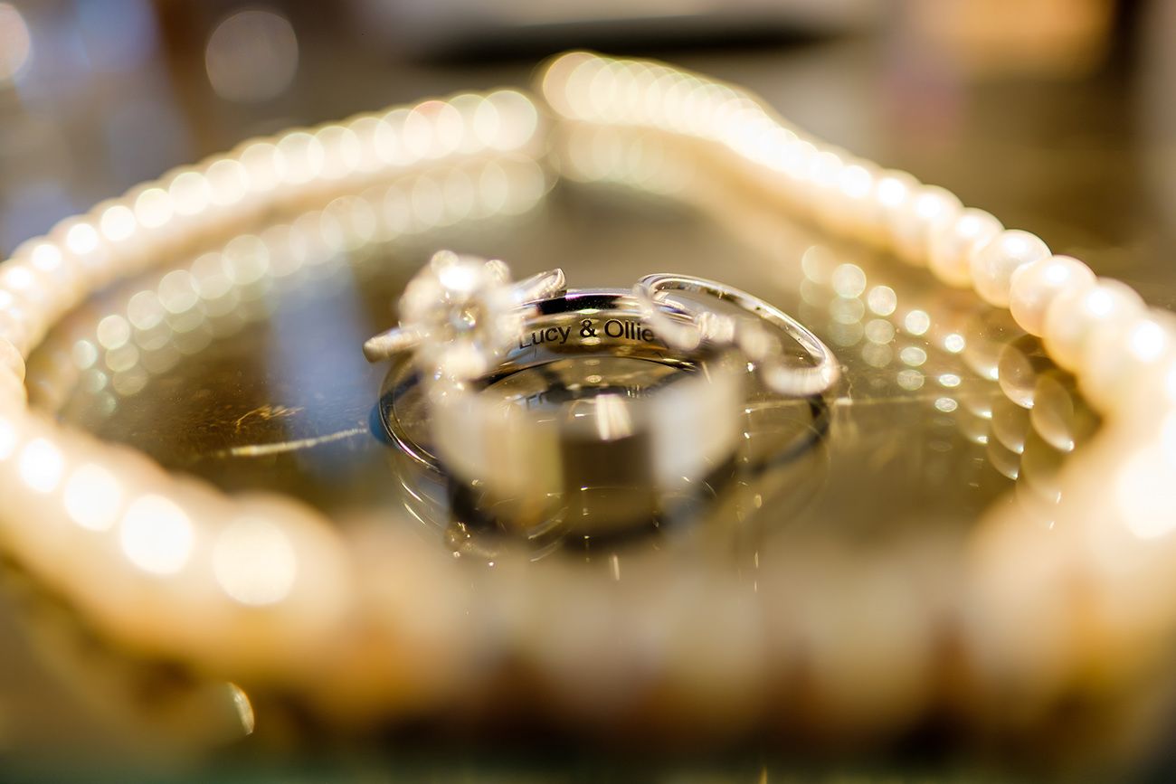 Macro shot of wedding rings with shallow depth of field and bokeh lighting effects.