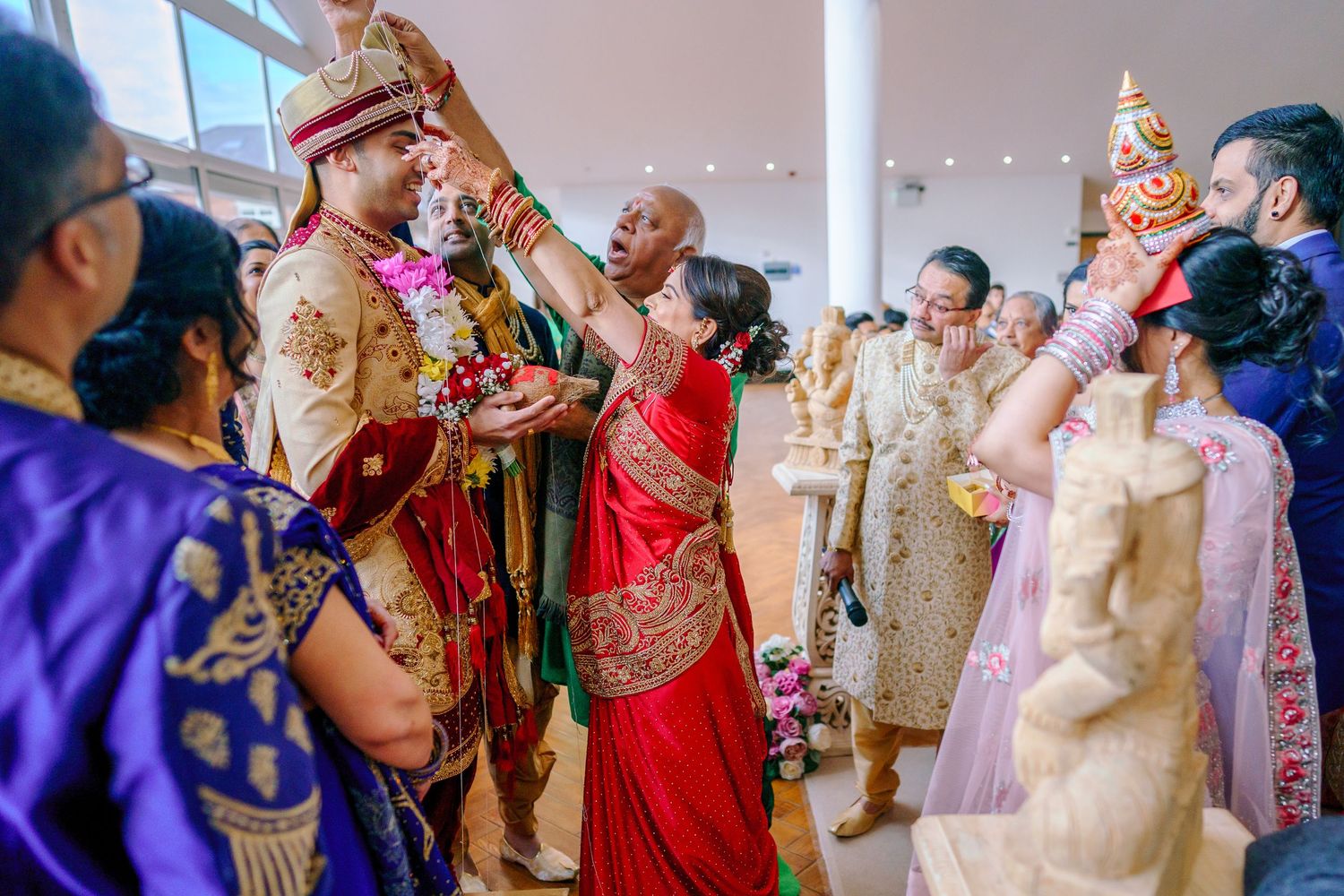 Guests celebrate at a traditional Indian wedding ceremony with colorful attire and decorative elements.