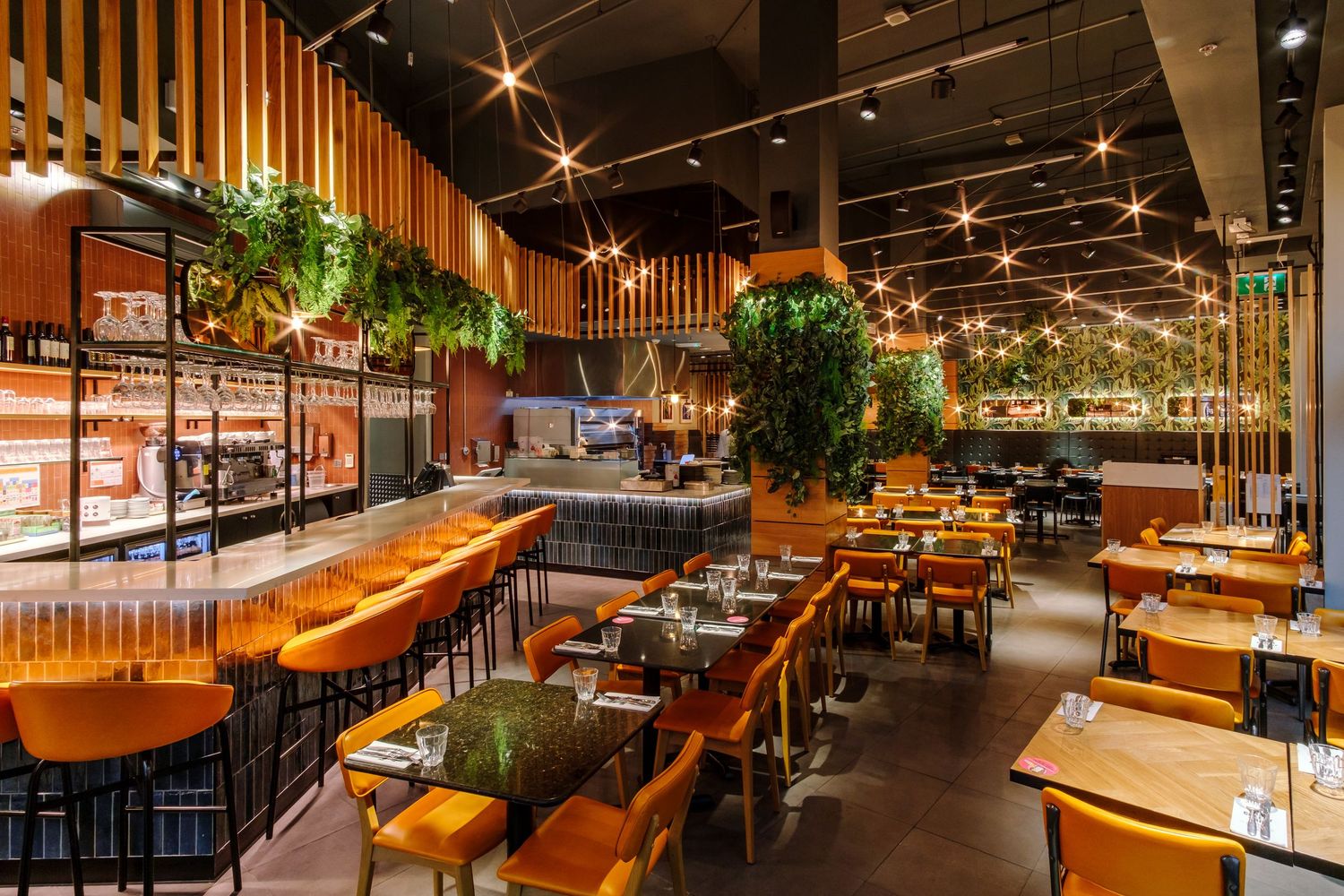 Modern restaurant interior with warm wood paneling and ambient lighting creating an inviting dining atmosphere.