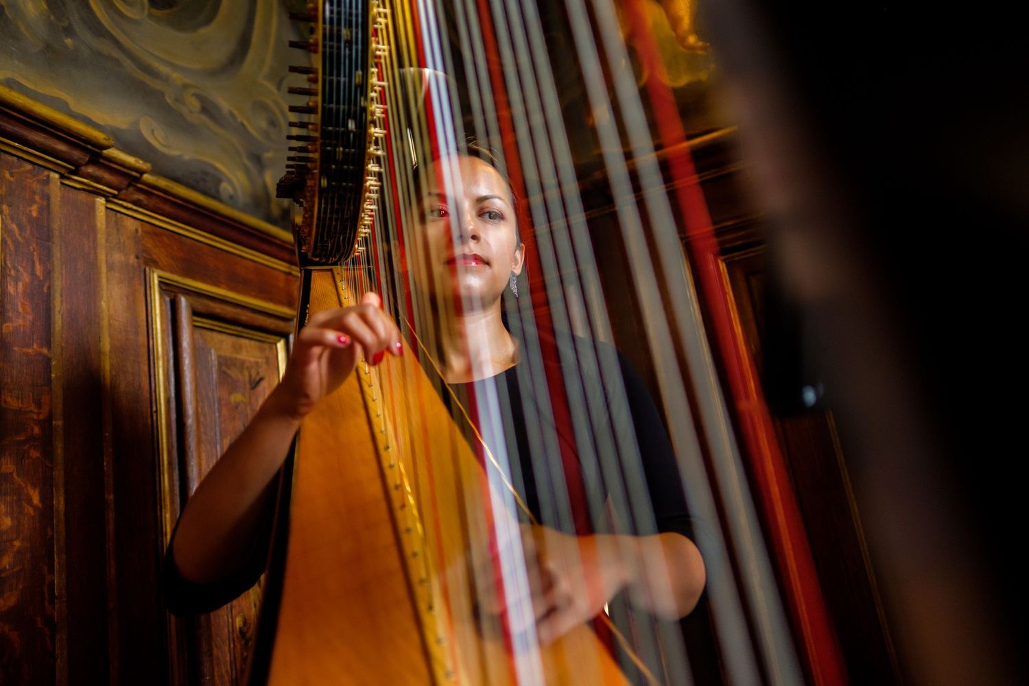 Close-up view of an elegant harp being played during a wedding ceremony.