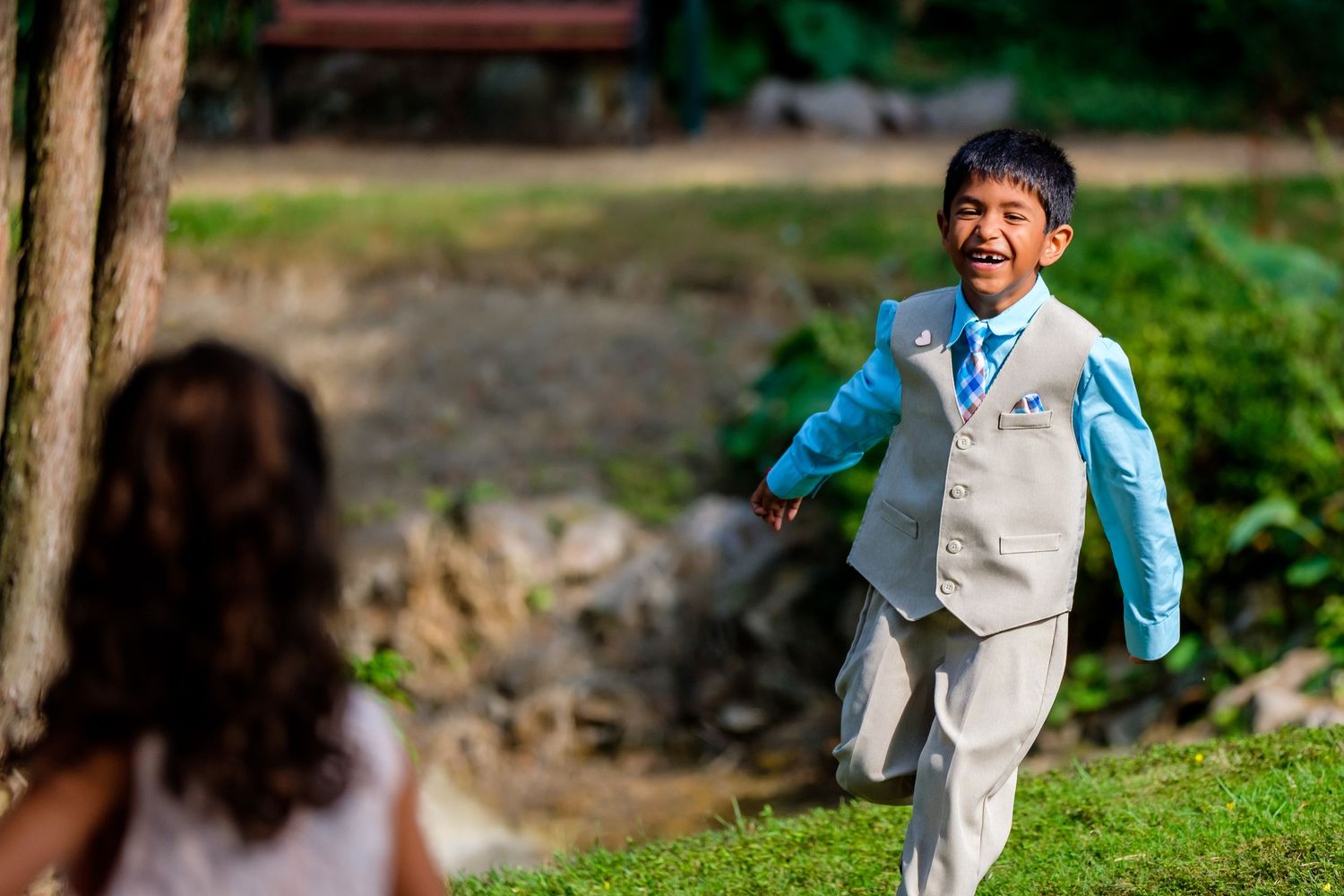 Children running and playing outdoors on grass in casual attire.