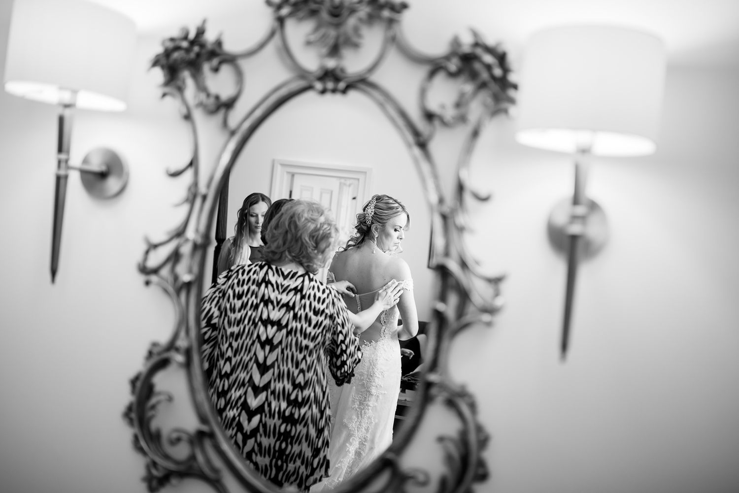 Elegant mirror reflections capture bridal preparation moments in black and white.