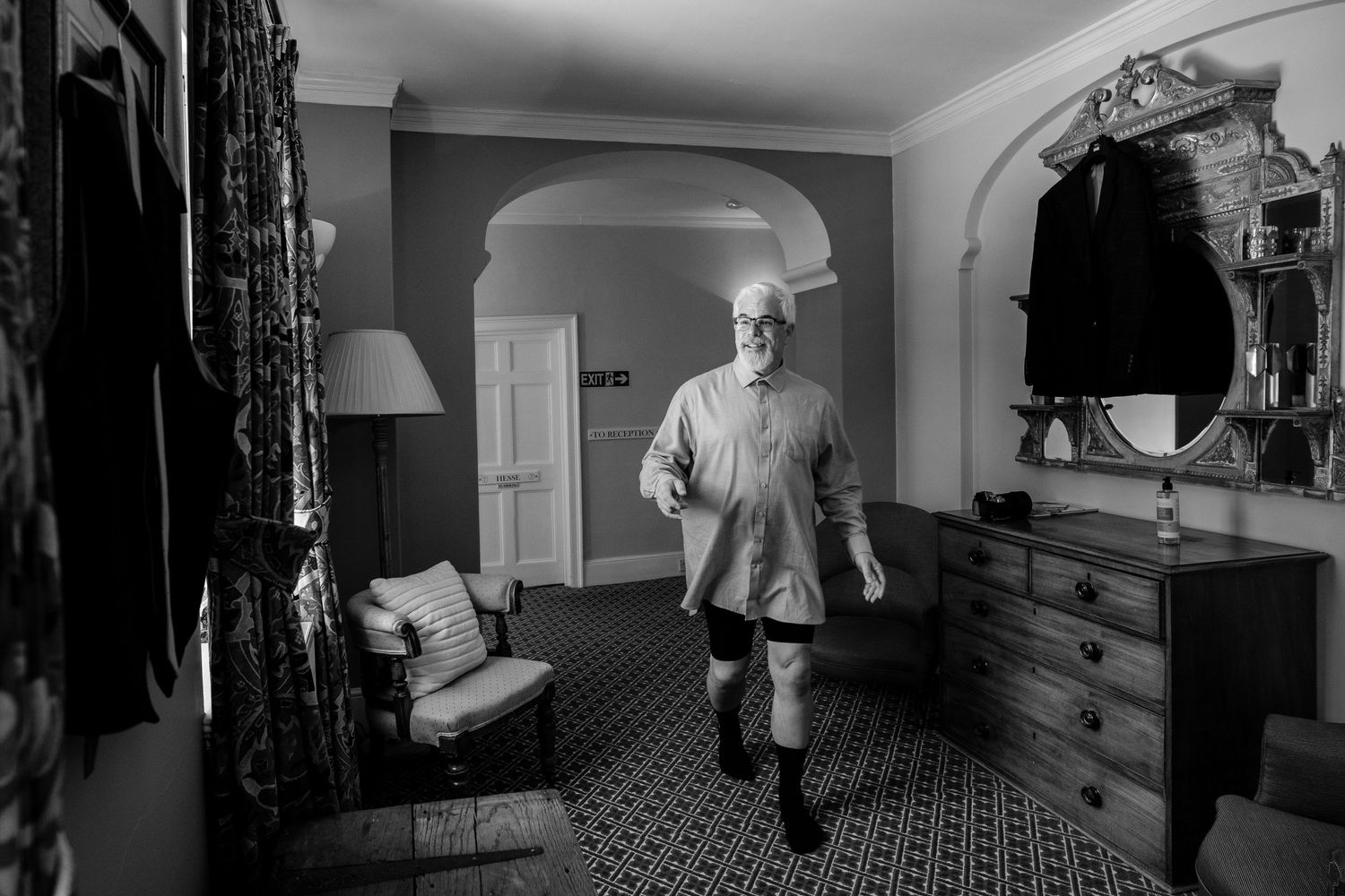 Black and white film strip showing multiple frames of a person walking down a hallway in a hotel or apartment building.