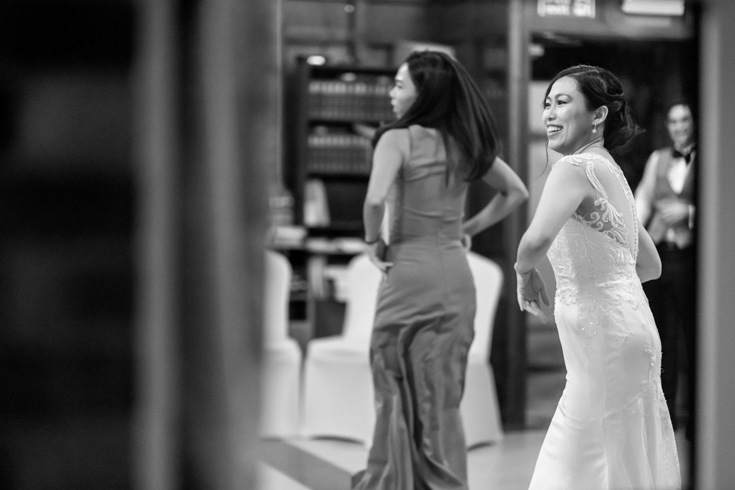 Two people in formal attire dancing and celebrating at an indoor event.