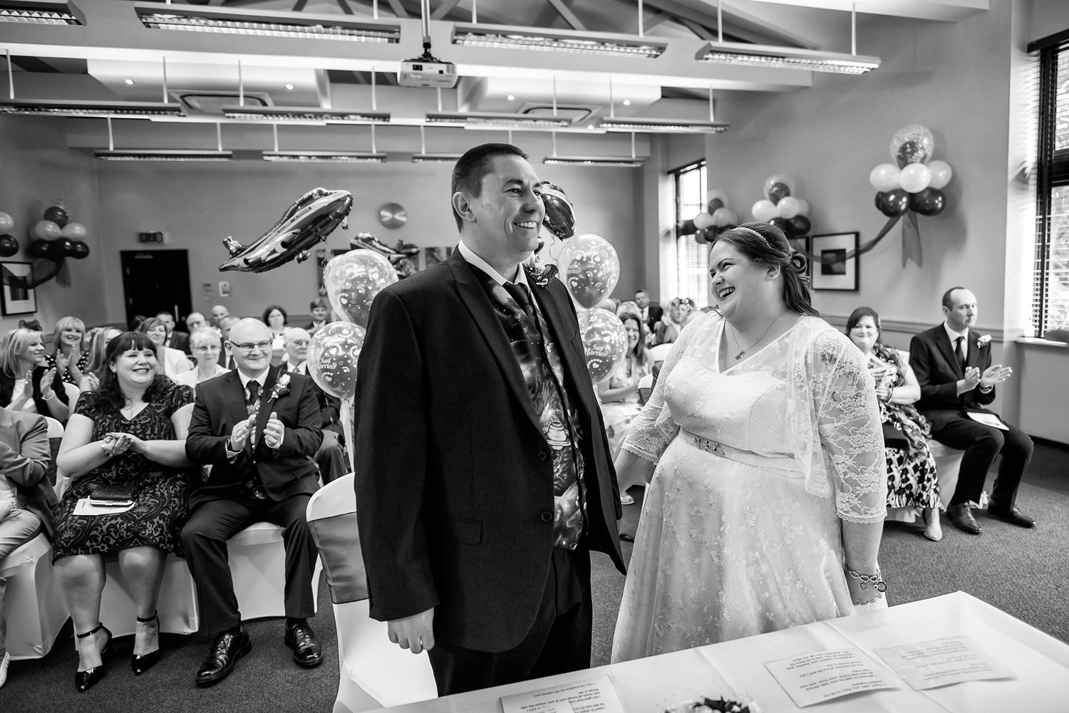Wedding reception celebration in a spacious venue with guests dancing.