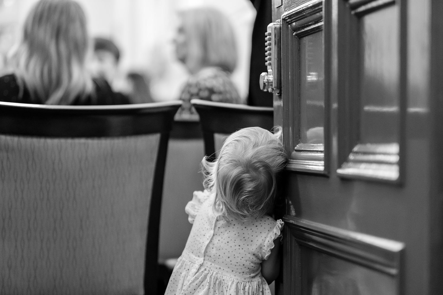 A black and white wedding reception sequence showing joyful moments and laughter between guests at an indoor venue.