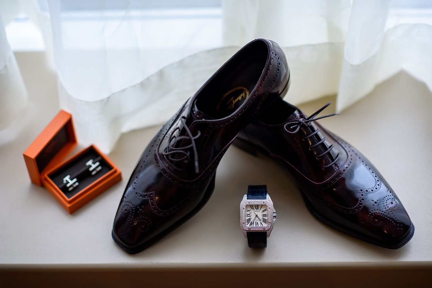 Collection of formal black dress shoes arranged on white surface.