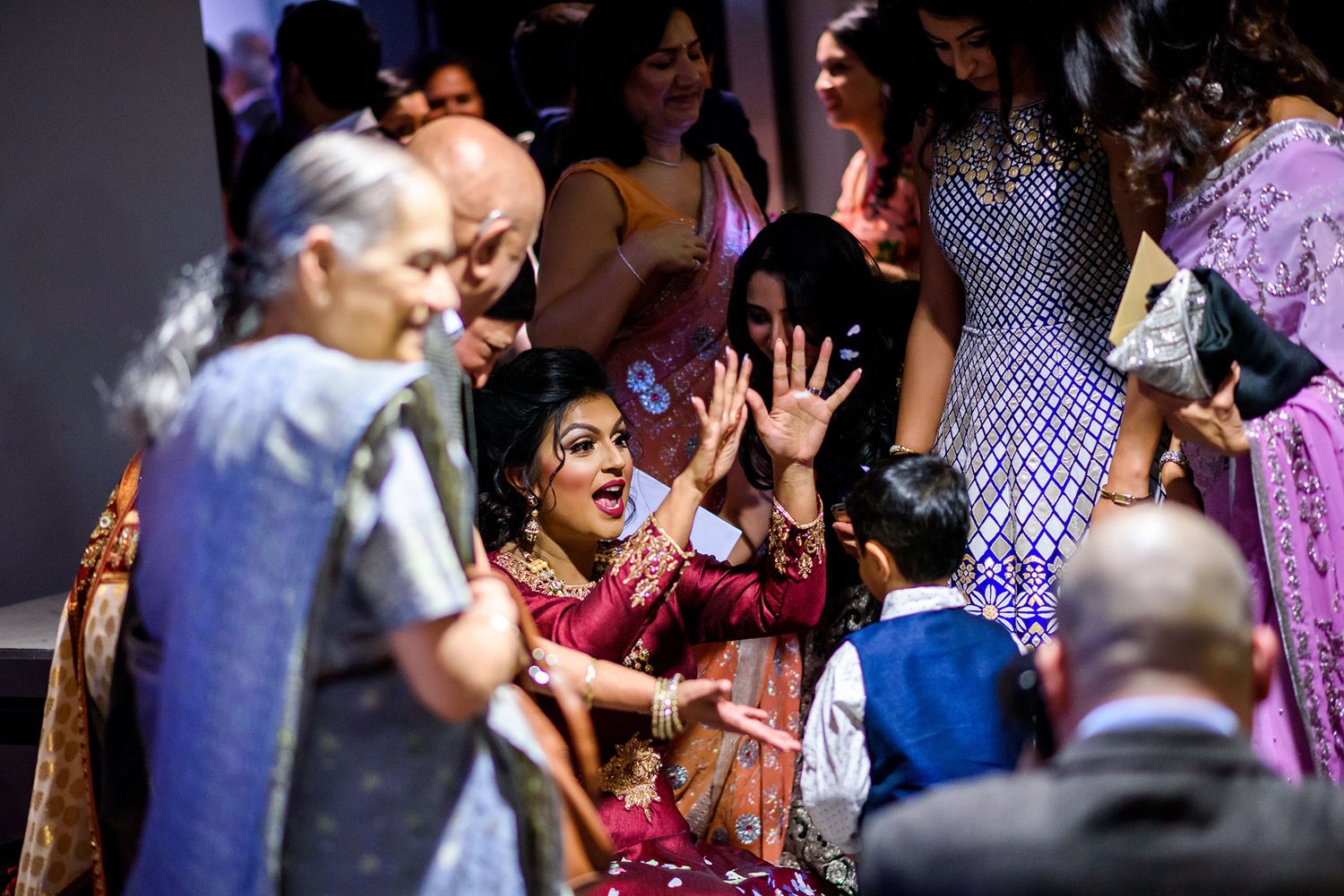 Candid shot of wedding guests celebrating and waving during a reception event.