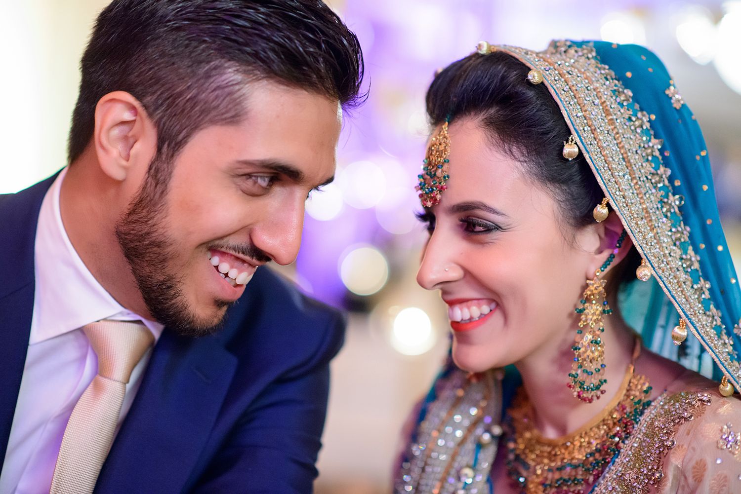 Romantic wedding moments captured with purple ambient lighting and elegant decor.