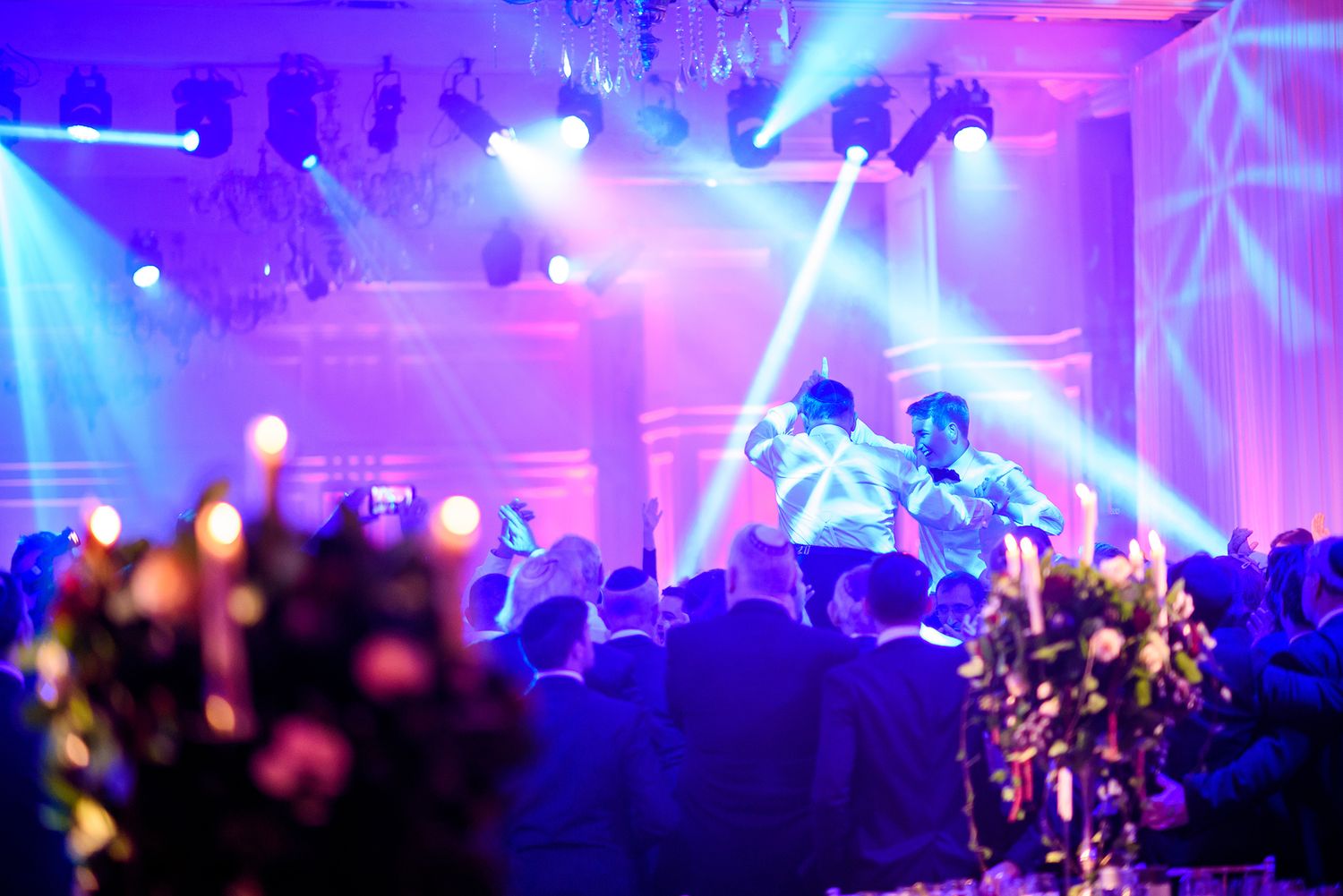 Dance floor atmosphere with vibrant purple lighting and crowd silhouettes.