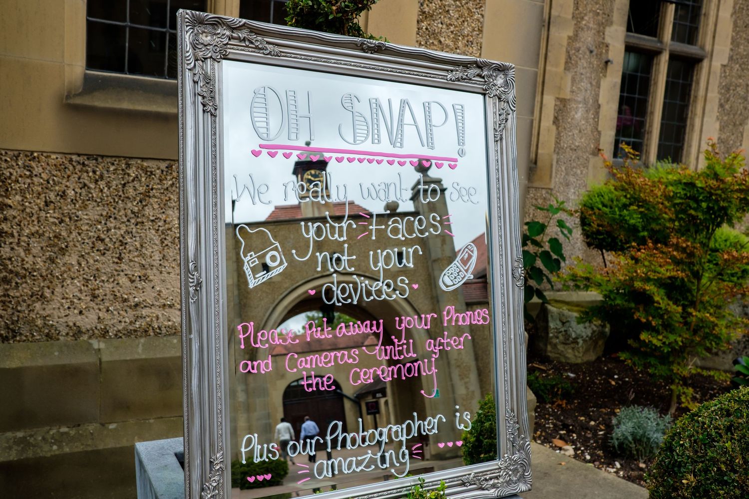 Handwritten welcome sign on glass window with decorative floral elements.