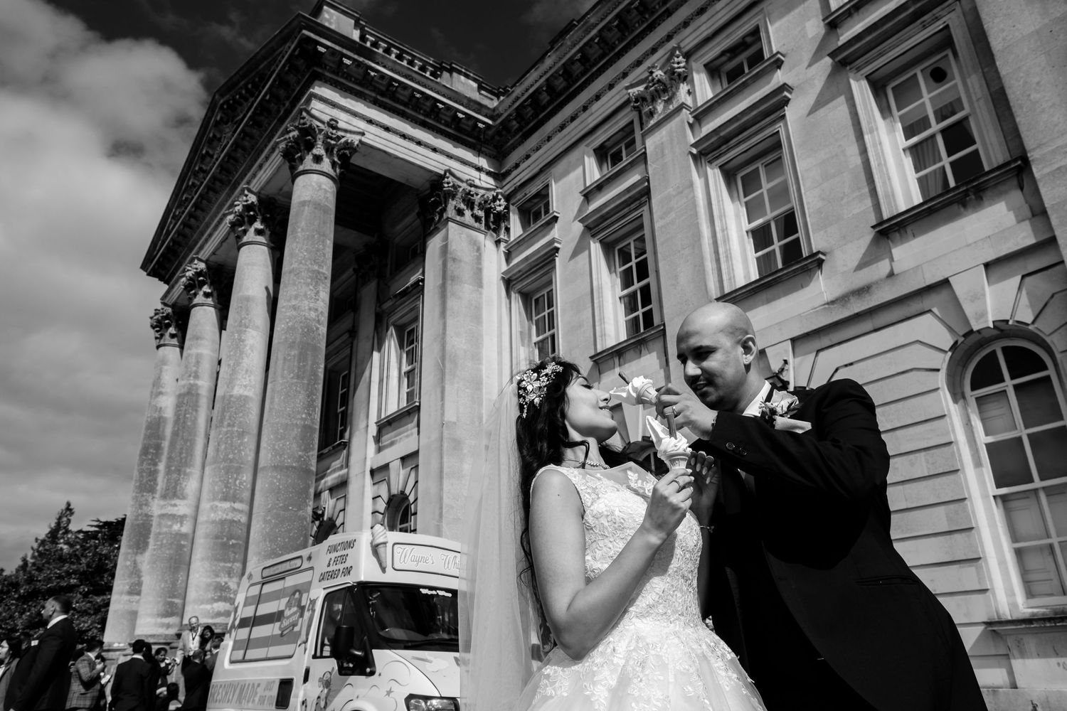 Black and white photos capture emotional wedding moments outside a classic stone building.