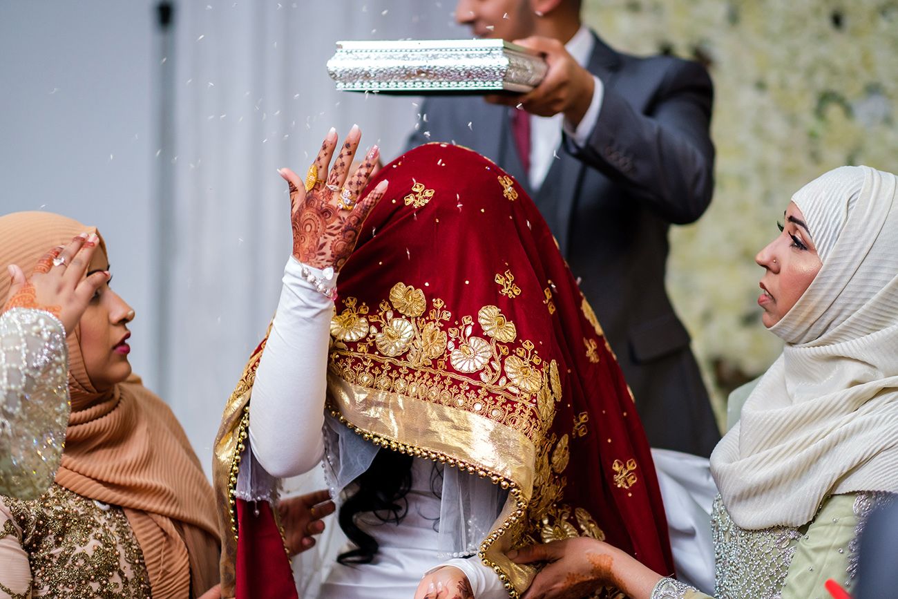 Traditional wedding ceremony with ornate red and gold cultural attire and decor.