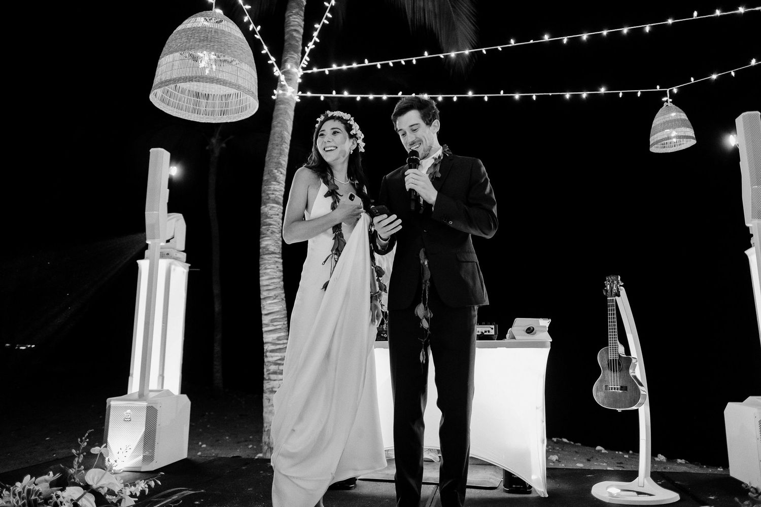 Wedding ceremony under twinkling string lights at night creates romantic ambiance.