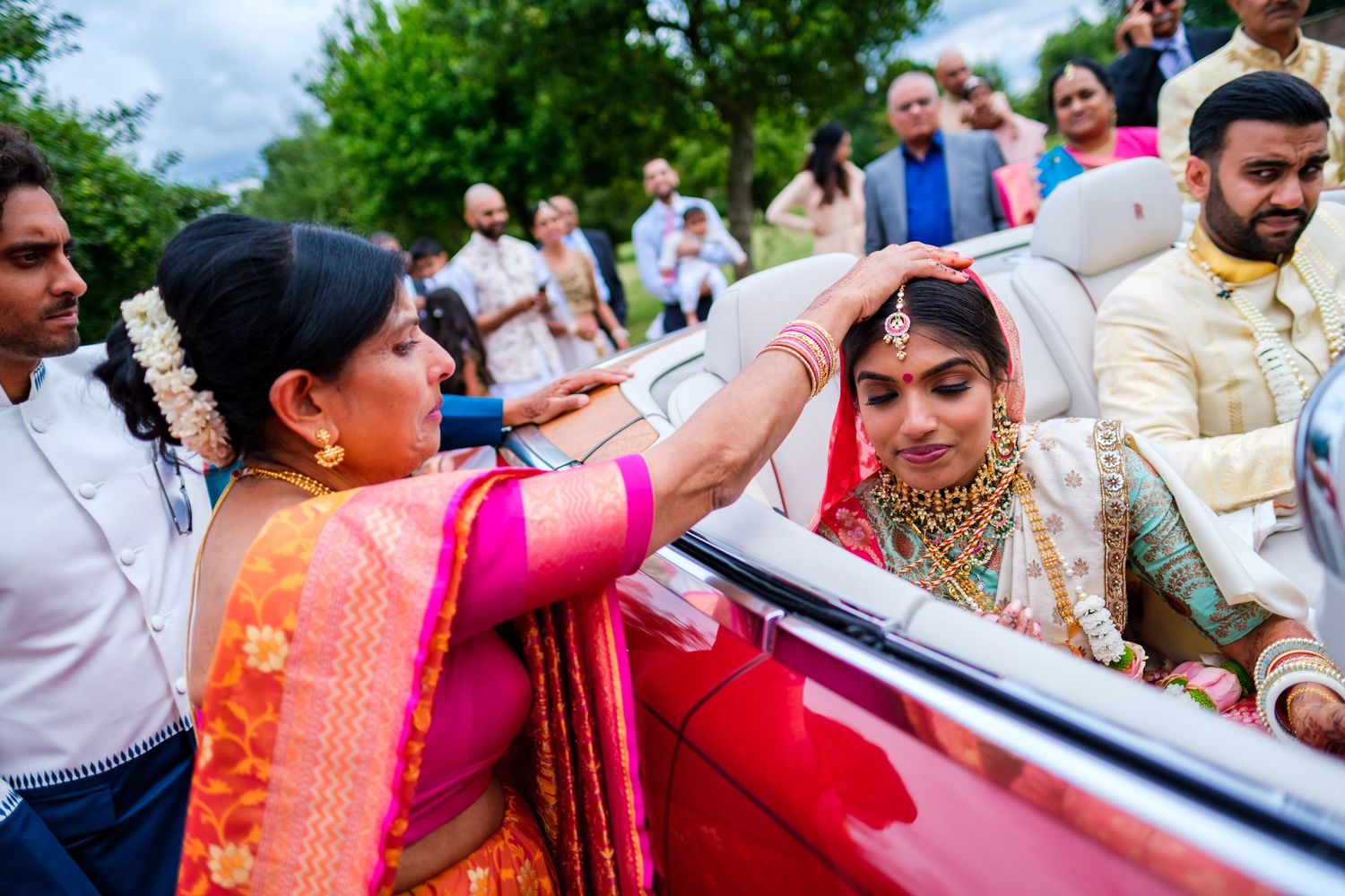 A group celebrates at a traditional Indian wedding ceremony with colorful saris and festive decorations.