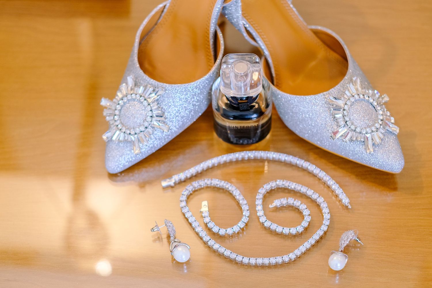 Pearl necklaces and bridal accessories displayed on a wooden surface with warm lighting.