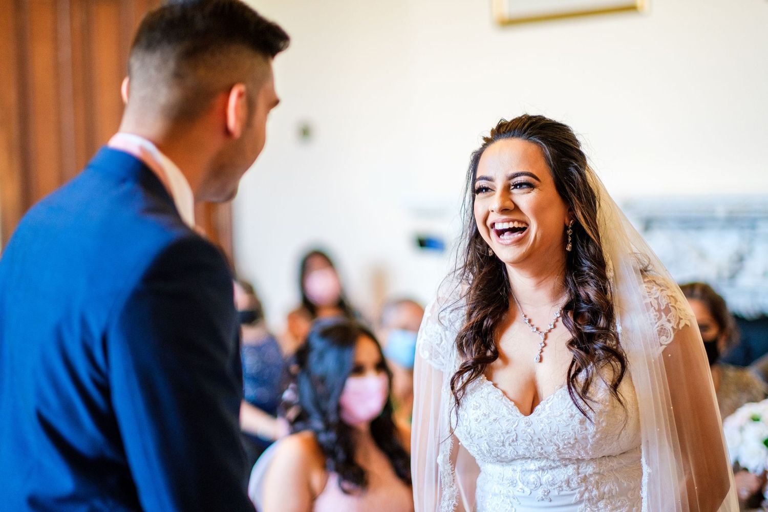 Wedding celebration scene showing laughter and embraces between guests in an elegant indoor venue.