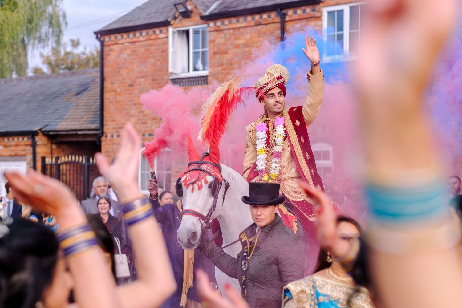 Colorful powder and confetti fill the air during a festive outdoor celebration near brick buildings.