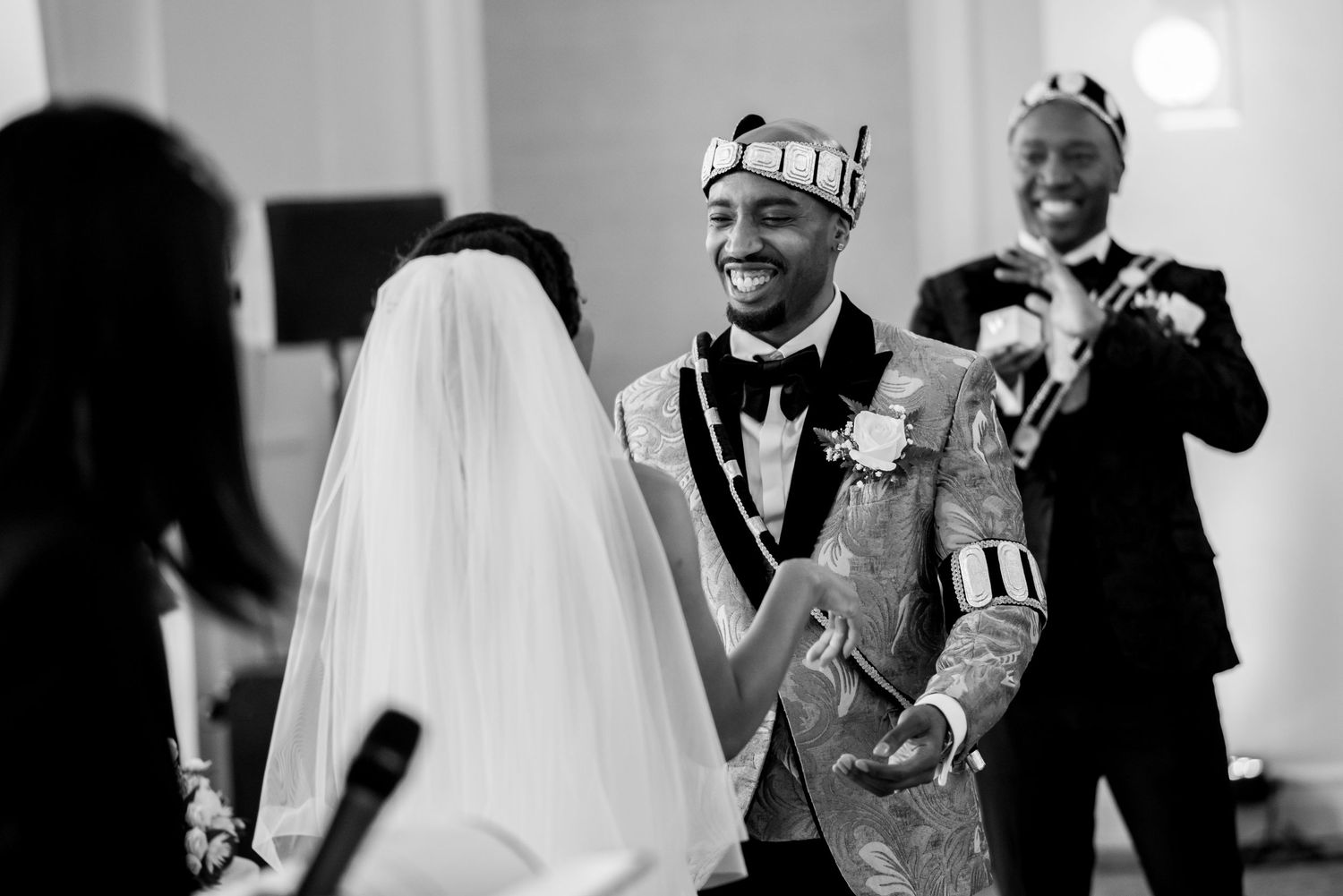 Black and white photo of wedding guests enjoying a lively dance celebration.